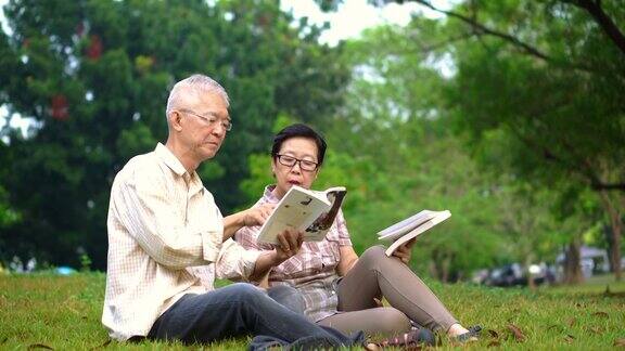 一对亚洲老夫妇在公园看书花宝贵的时间永远不要停止学习新东西