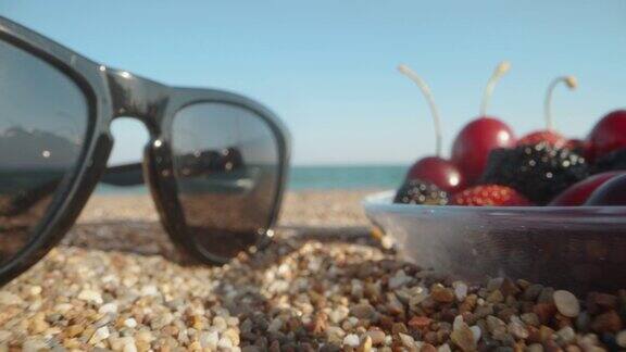 海滩上的一盘浆果大海草莓配樱桃和桑葚反映在眼镜Dolly滑块极端特写Laowa调查缓慢的莫