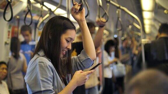 年轻的亚洲女人在地铁里打电话