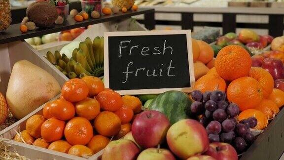 各种水果放在架子上的盒子上铭牌上写着“新鲜水果”