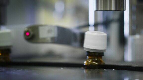 在制药厂的玻璃器皿瓶的自动生产线上生产药物的特写