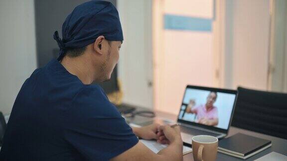 亚裔华人医生在医生办公室与他的老病人视频通话