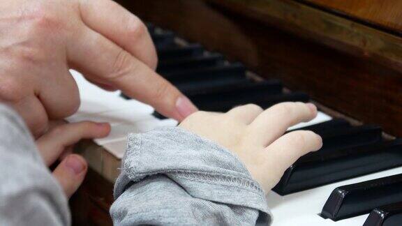 一个老师用手给孩子弹奏钢琴的特写镜头