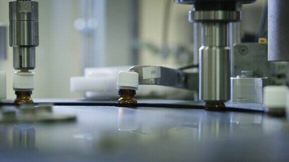 在制药厂的玻璃器皿瓶的自动生产线上生产药物的特写