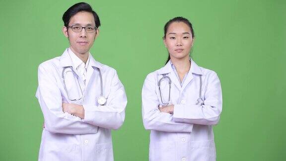 年轻幸福的亚洲夫妇医生双臂交叉在一起