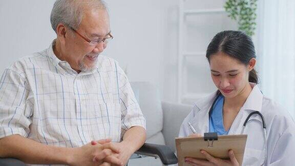 亚洲年轻女子照顾老人坐在轮椅上在家里迷人美丽的护士医生感到高兴交谈和支持老人年长成熟的男病人在养老院护理