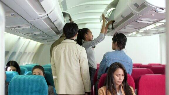 乘客在飞机上把行李放在行李架上