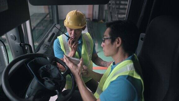 亚洲华人半挂车司机与工厂仓库工人沟通交货装箱单