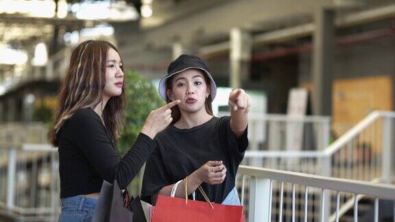 亚洲快乐女性观光散步与持有购物袋在一个景点概念时尚女孩购物生活方式