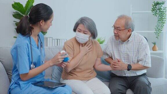 亚洲老年夫妇与护理员在敬老院咨询医生治疗师药剂师女孩拿着药瓶在家里的客厅里给年迈的祖父母解释处方