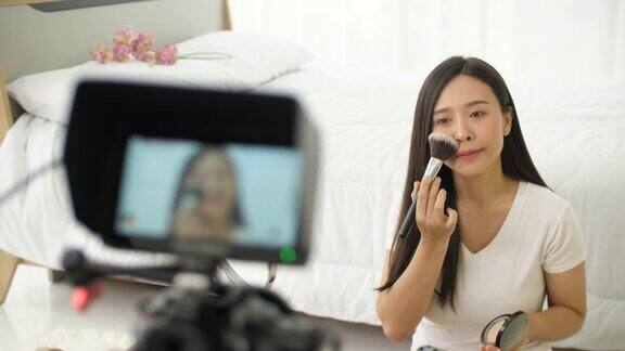 专注的年轻亚洲女人在镜子前化妆化妆视频
