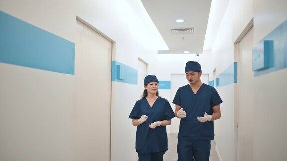 2名亚裔华人外科医生在医院走廊上交谈
