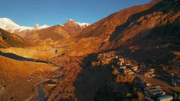 在高山景观中飞越雄伟的山谷黄金时段的河流和典型的村庄马南山谷安纳普尔纳环行尼泊尔