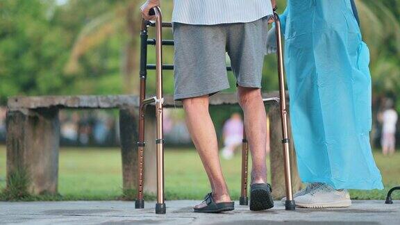亚洲医疗保险中国女性理疗师纠正姿势帮助老年男子在公园行走与移动步行者