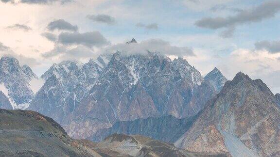 在巴基斯坦罕萨山谷地区的帕苏山谷喀喇昆仑山脉的秋天雪山的壮丽景色的延时移动云日出