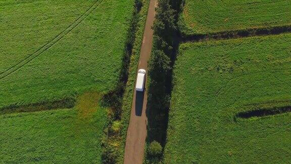 摄像机跟踪一辆白色货车从一条小路上开过