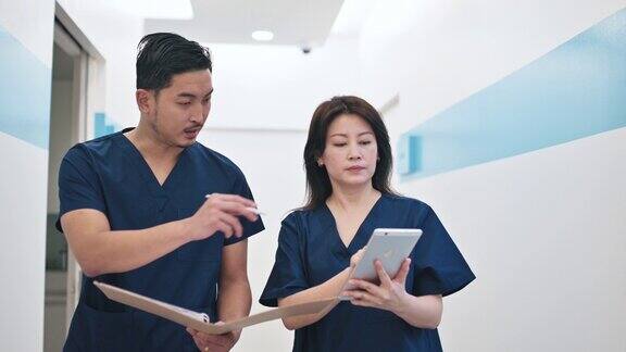 2名亚裔中国医生在医院走廊上交谈