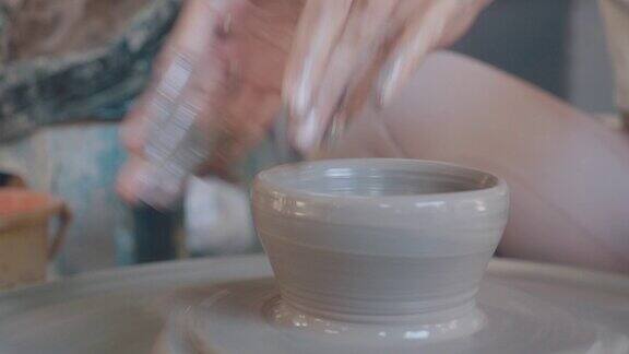 近距离的亚洲妇女粘土艺术家在她的工作室与纺纱陶轮工作