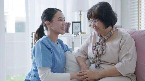 年轻的亚洲妇女或护士家微笑看着镜头与老祖母给予支持同情老人女士或老年人在辅助生活家庭照顾心理健康疾病救济