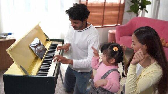 周末活动亚洲家庭唱歌跳舞弹钢琴用数字平板教钢琴在家娱乐