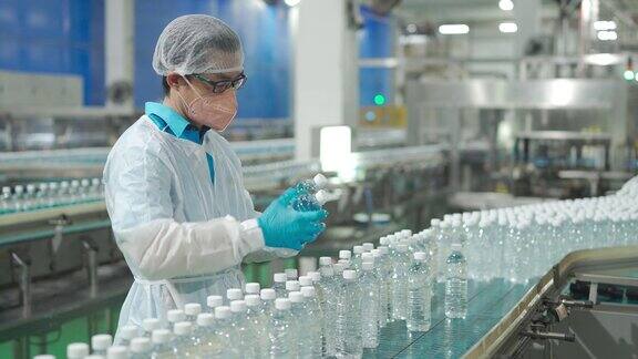 男性亚洲华人饮水厂生产线工人有个人防护用品日常检查水瓶工作