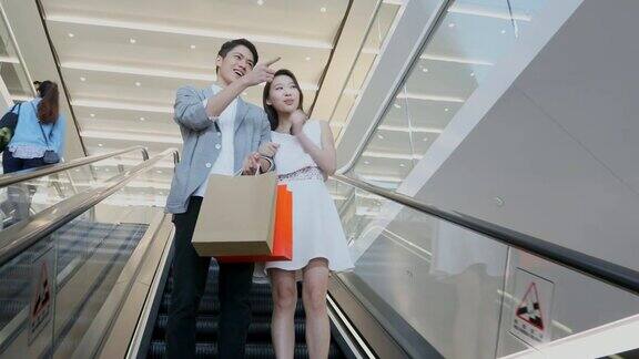 购物中心电梯上的一对亚洲夫妇