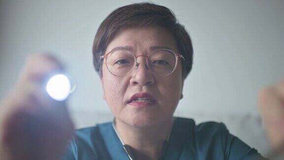 个人观点亚洲华人女医生用手电筒检查病人的口腔