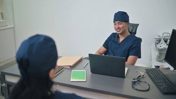 2亚裔华人外科医生在医生办公室讨论