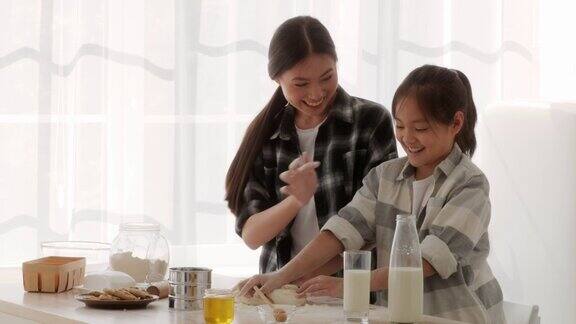 中国妈妈和女儿在厨房里玩面粉