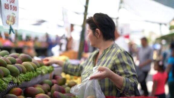 日本妇女在农贸市场买芒果