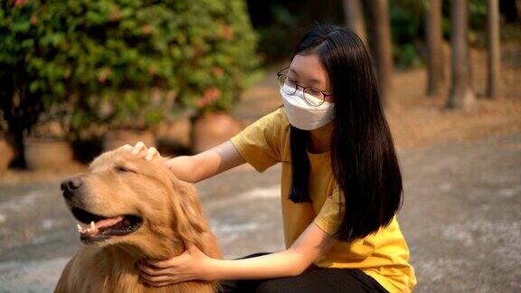 少女在空气污染面具拥抱金毛猎犬