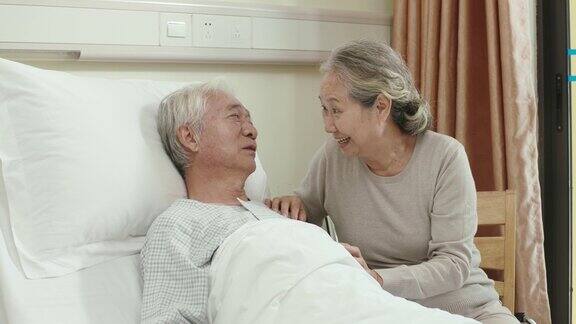 亚洲老妇人在床边与丈夫交谈
