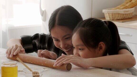 韩国妈妈和女儿在室内烤饼干
