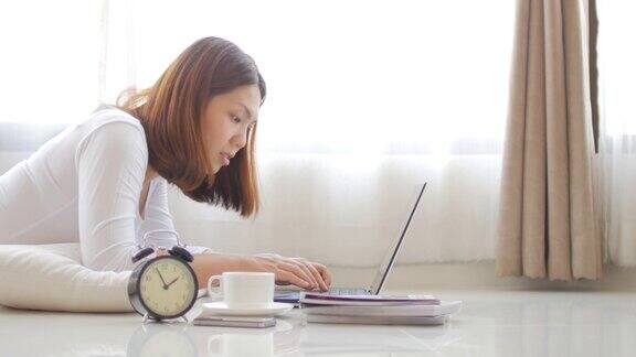 年轻女子在家用笔记本电脑和咖啡休息休息