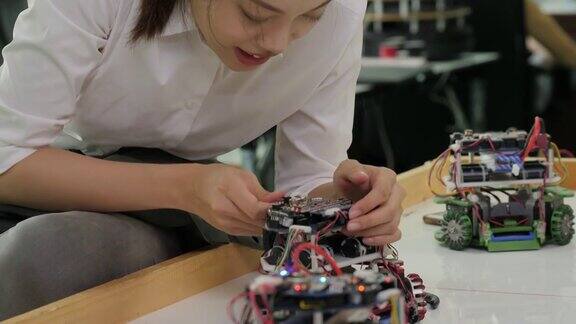 女电子工程师与机器人一起工作在车间建造、修理机器人有技术或创新观念的人