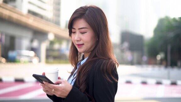 亚洲女商人在街上使用智能手机