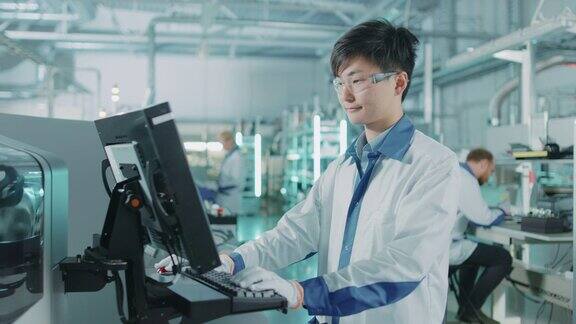 在高科技工厂亚洲工程师使用计算机编程的取放表面贴装电子机械的印刷电路板装配线