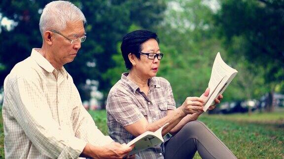 一对亚洲老夫妇在公园看书花宝贵的时间永远不要停止学习新东西