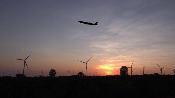 飞机与风力涡轮机在日落