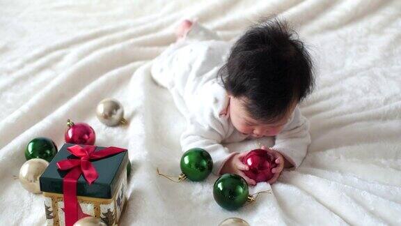 亚洲小女孩玩圣诞装饰品和礼物盒