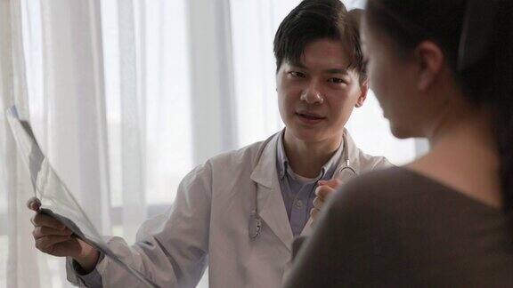 亚洲男性医生在办公室检查女性患者