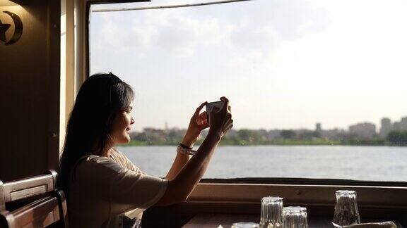 一个快乐的女人的画像她在日落时分乘船在开罗的尼罗河上旅行