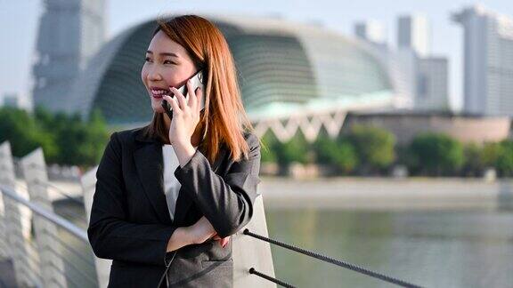 亚洲女商人在城市里用电话打电话