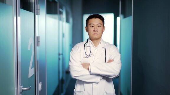 肖像自信的亚洲医生男子严肃地看着镜头背景是一个现代化的医院医疗诊所