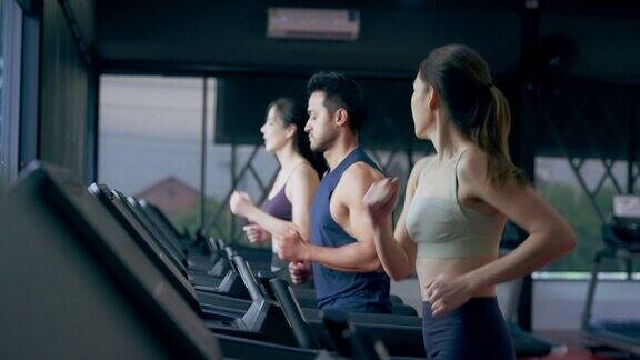 在健身馆的健身课上健康的年轻男女在跑步机上跑步