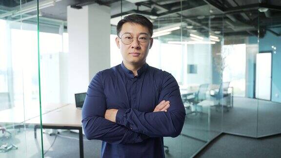 自信的IT专家程序员的肖像与眼镜看着相机在现代办公中心亚洲