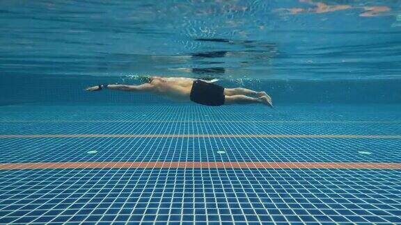 4k水下拍摄亚洲人在游泳池游泳