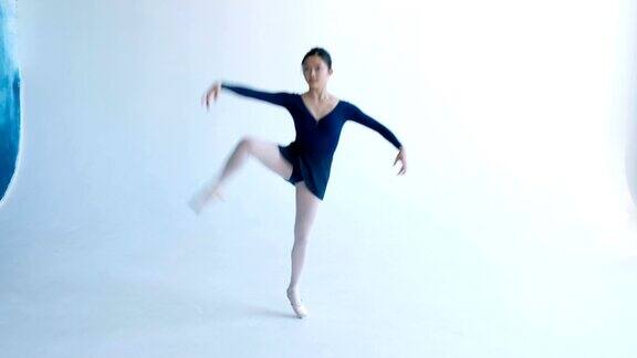 穿着蓝色裙子的女芭蕾舞者在舞中抬腿旋转