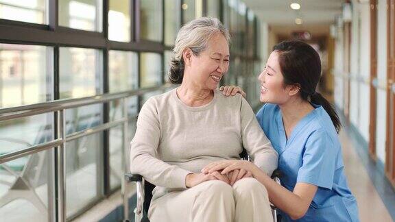 友善的女员工在走廊里与亚洲老妇人交谈