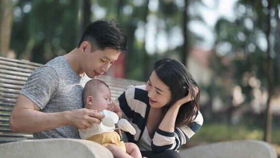 亚洲华人父母周末早上在公园里和他们的孩子亲密无间